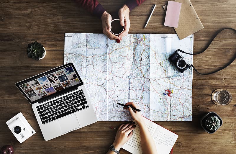 Person_holding_black_pen_pointing_at_white_and_brown_map